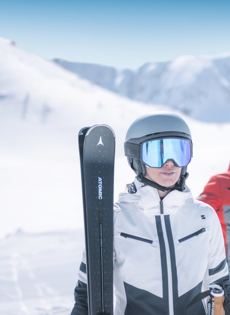Zwei Skifahrer startklar vor verschneiter Bergkulisse in Ski amadé | © Ski amadé GmbH Zwei Skifahrer in moderner Ausrüstung stehen auf einer verschneiten Piste mit Helm und Skibrille, bereit für die Abfahrt. | © Ski amadé GmbH